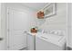 Bright laundry room features a washer and dryer with shelving for storage at 5632 Summit Pointe Cir # 101, Bradenton, FL 34210