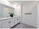 Bright bathroom featuring double sinks with white cabinets, a large mirror, and tile floors at 5800 Elegant Orchid Way, Sarasota, FL 34232