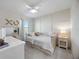 Bright bedroom with white paneled accent wall, desk with vanity, and plush carpeting at 5800 Elegant Orchid Way, Sarasota, FL 34232
