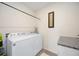Modern laundry room equipped with a side-by-side washer and dryer and folding counter at 5800 Elegant Orchid Way, Sarasota, FL 34232