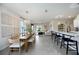 Bright living area adjacent to a dining room and kitchen with counter seating and patio access at 5800 Elegant Orchid Way, Sarasota, FL 34232