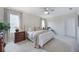 Bright main bedroom features neutral decor, a ceiling fan, and bedside table with lamps at 5800 Elegant Orchid Way, Sarasota, FL 34232