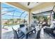 Inviting screened-in patio with a dining table, outdoor seating, and a refreshing pool view at 5800 Elegant Orchid Way, Sarasota, FL 34232
