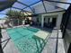 Sparkling pool with screened-in patio, featuring an outdoor kitchen and lounge area at 5800 Elegant Orchid Way, Sarasota, FL 34232
