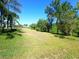 Expansive backyard features a well-manicured lawn and mature trees, ideal for outdoor activities and relaxation at 6631 63Rd E Ter, Bradenton, FL 34203