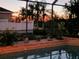 Screened pool at sunset surrounded by lush foliage creates a peaceful backyard oasis at 6631 63Rd E Ter, Bradenton, FL 34203