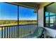 Relaxing screened balcony with a lounge chair overlooking a golf course and lake view at 7005 River Hammock Dr # 402, Bradenton, FL 34212