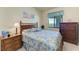 Charming bedroom featuring a decorative bed, wooden nightstands, and a large window with scenic views at 7005 River Hammock Dr # 402, Bradenton, FL 34212
