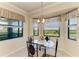 Cozy dining area with a glass table set against a backdrop of scenic views from large windows at 7005 River Hammock Dr # 402, Bradenton, FL 34212