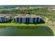 Waterfront condo building with tile roof, well-maintained landscaping, and pristine green lawn at 7005 River Hammock Dr # 402, Bradenton, FL 34212
