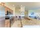 Charming kitchen with stainless steel appliances, wood cabinets, granite countertops, and a breakfast bar at 7005 River Hammock Dr # 402, Bradenton, FL 34212
