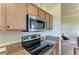 Close-up of kitchen appliances, including a stainless steel microwave and stove with granite countertops at 7005 River Hammock Dr # 402, Bradenton, FL 34212
