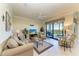 Inviting living room with neutral tones, tile floor, ceiling fan, and sliding glass doors leading to lanai at 7005 River Hammock Dr # 402, Bradenton, FL 34212