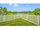 A lush green backyard with white picket fence provides scenic views of a tranquil pond with fountain at 7107 58Th E Ter, Palmetto, FL 34221