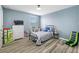 A bedroom with wood-look floors is accented by a ceiling fan, and features a large window for natural light at 7107 58Th E Ter, Palmetto, FL 34221