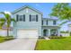 Two-story home showcasing a lush lawn, landscaping, a two-car garage, and decorative shutters at 7107 58Th E Ter, Palmetto, FL 34221