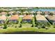 Aerial view of homes with screened lanai, pool, landscaping, and peaceful lakeside views at 7113 Whittlebury Trl, Bradenton, FL 34202