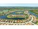 Aerial view of a residential community surrounding a lake featuring well-kept lawns and tile roofs at 7113 Whittlebury Trl, Bradenton, FL 34202