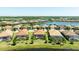 Scenic aerial view showcasing a community with homes surrounding a serene lake, each with private screened-in pools at 7113 Whittlebury Trl, Bradenton, FL 34202