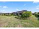 Expansive backyard featuring a screened lanai, lush landscaping, and ample green space for outdoor enjoyment at 7113 Whittlebury Trl, Bradenton, FL 34202