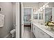 Bathroom with a double vanity and tile flooring that leads into a bedroom at 7113 Whittlebury Trl, Bradenton, FL 34202