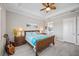 Bright bedroom with a wood bed, ceiling fan, and a view to the bathroom at 7113 Whittlebury Trl, Bradenton, FL 34202