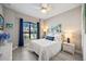 Bedroom with white furnishings, blue curtains, tile floors, and bright, natural light at 7113 Whittlebury Trl, Bradenton, FL 34202
