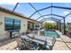 Exterior of home features a dining area with a screened-in lanai and a pool for outdoor relaxation at 7113 Whittlebury Trl, Bradenton, FL 34202
