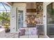 Covered outdoor kitchen boasts stone accents, a grill, refrigerator, and comfortable seating for enjoying outdoor cooking at 7113 Whittlebury Trl, Bradenton, FL 34202
