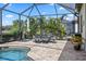 Screened lanai features a dining area and views of lush landscaping, providing an ideal space for outdoor meals at 7113 Whittlebury Trl, Bradenton, FL 34202