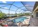Screened-in pool and spa overlook a serene lake, complemented by poolside seating for ultimate relaxation at 7113 Whittlebury Trl, Bradenton, FL 34202