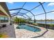 Spacious screened-in pool with spa offers serene lake views, complemented by a fire pit and outdoor seating at 7113 Whittlebury Trl, Bradenton, FL 34202