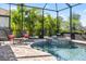 Screened-in pool and spa surrounded by lush landscaping, with chaise lounges creating a tranquil oasis at 7113 Whittlebury Trl, Bradenton, FL 34202