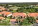 An aerial view showing the building with a red tile roof next to a golf course and mature Florida landscape at 7115 Boca Grove Pl # 204, Lakewood Ranch, FL 34202