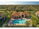 Aerial view of a large pool, surrounded by palm trees and lounge chairs at 7115 Boca Grove Pl # 204, Lakewood Ranch, FL 34202