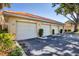 Exterior view of multiple garages with well-maintained landscaping and red tile roofs at 7115 Boca Grove Pl # 204, Lakewood Ranch, FL 34202