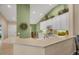 A modern kitchen features a breakfast bar, white cabinets, and neutral countertops with stainless appliances at 7115 Boca Grove Pl # 204, Lakewood Ranch, FL 34202