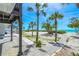 Beautiful backyard featuring a paved walkway, lush greenery and multiple palm trees next to the beach at 722 N Manasota Key Rd, Englewood, FL 34223