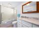 A well lit full bathroom with a shower and tub, marble countertops and modern fixtures at 722 N Manasota Key Rd, Englewood, FL 34223