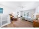 Bright bedroom with a ceiling fan, balcony doors, and a charming reading corner at 722 N Manasota Key Rd, Englewood, FL 34223