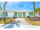 Inviting home entrance with a bright yellow double door and colorful landscaping at 722 N Manasota Key Rd, Englewood, FL 34223