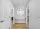 Hallway with a large circular mirror between two doors and light colored wood floors at 722 N Manasota Key Rd, Englewood, FL 34223