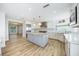 Modern kitchen features white cabinetry, stainless steel appliances, a center island, and wood flooring at 722 N Manasota Key Rd, Englewood, FL 34223