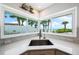 Modern kitchen sink area with beach view, tiled backsplash and quartz countertops at 722 N Manasota Key Rd, Englewood, FL 34223