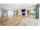 Expansive living room showcases a fireplace, wood floors, access to kitchen, and multiple doors to outdoor spaces at 722 N Manasota Key Rd, Englewood, FL 34223