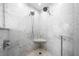 Close up of marble shower featuring two shower heads, a corner shelf, and decorative mosaic tile at 722 N Manasota Key Rd, Englewood, FL 34223