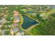 Aerial view of the home with a lake view, surrounded by golf course and tropical landscaping at 7305 Chatsworth Ct, University Park, FL 34201