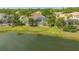 Aerial view of the backyard and screened-in pool with a lake view surrounded by mature landscaping at 7305 Chatsworth Ct, University Park, FL 34201