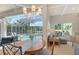 The dining area has a wood table, screened-in lanai overlooking a pool, and a view of the living space at 7305 Chatsworth Ct, University Park, FL 34201