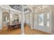 Elegant dining room with coffered ceiling, decorative columns, and large windows showcasing the beautiful view at 7305 Chatsworth Ct, University Park, FL 34201